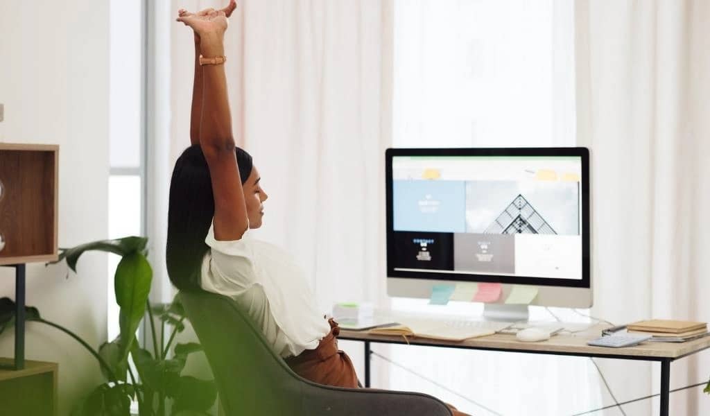 Bild på kvinna som sitter vid datorn med en ny och modern hemsida på skärmen.
